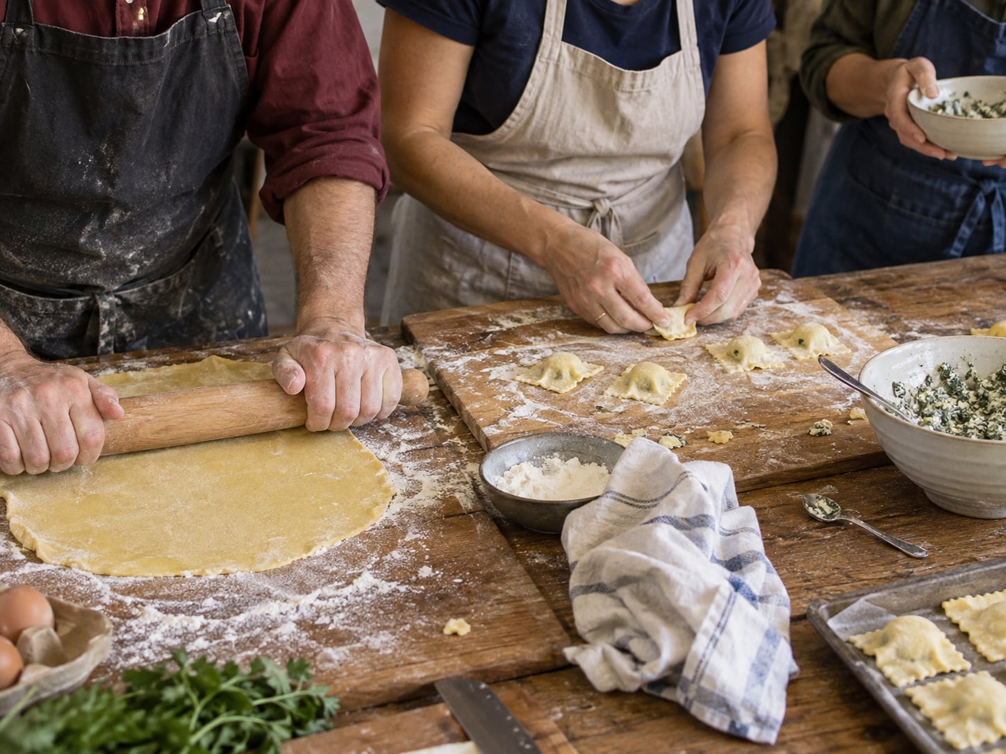 Mehrere Teilnehmer rollen Teig aus und formen Ravioli